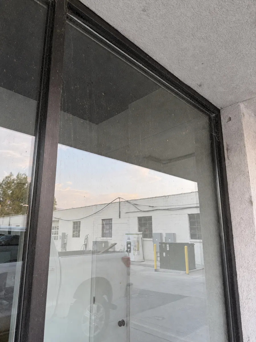 Storefront window and frame before cleaning, coated in dust and grime